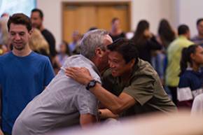 group of people with two people hugging at an event